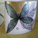 Vaso realizzato con varie tecnichetecnica a graffio per l'oro e il lustro pennino per il decoro a merletto nero, colori interferenti sul nero per le farfalle