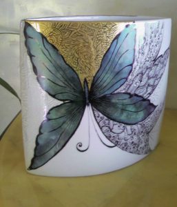 Vaso realizzato con varie tecnichetecnica a graffio per l'oro e il lustro pennino per il decoro a merletto nero, colori interferenti sul nero per le farfalle